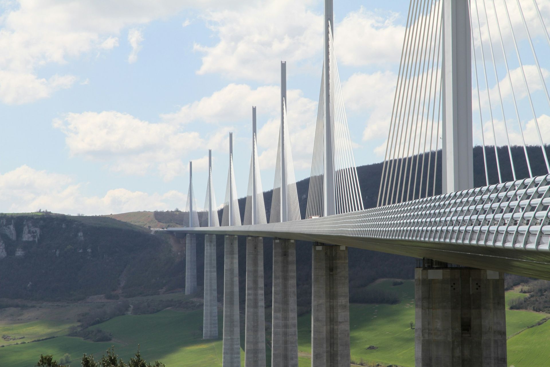 Millau Viaduct, a tall cable-stayed bridge over a valley, featuring multiple concrete pillars and support cables.