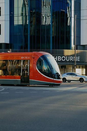 Red tram on a city street,