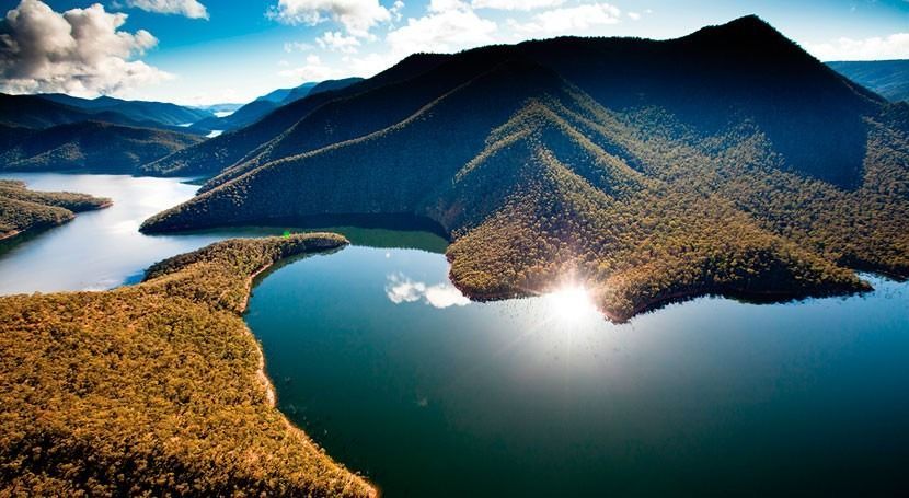 Lakes and forested mountains under sunlight.