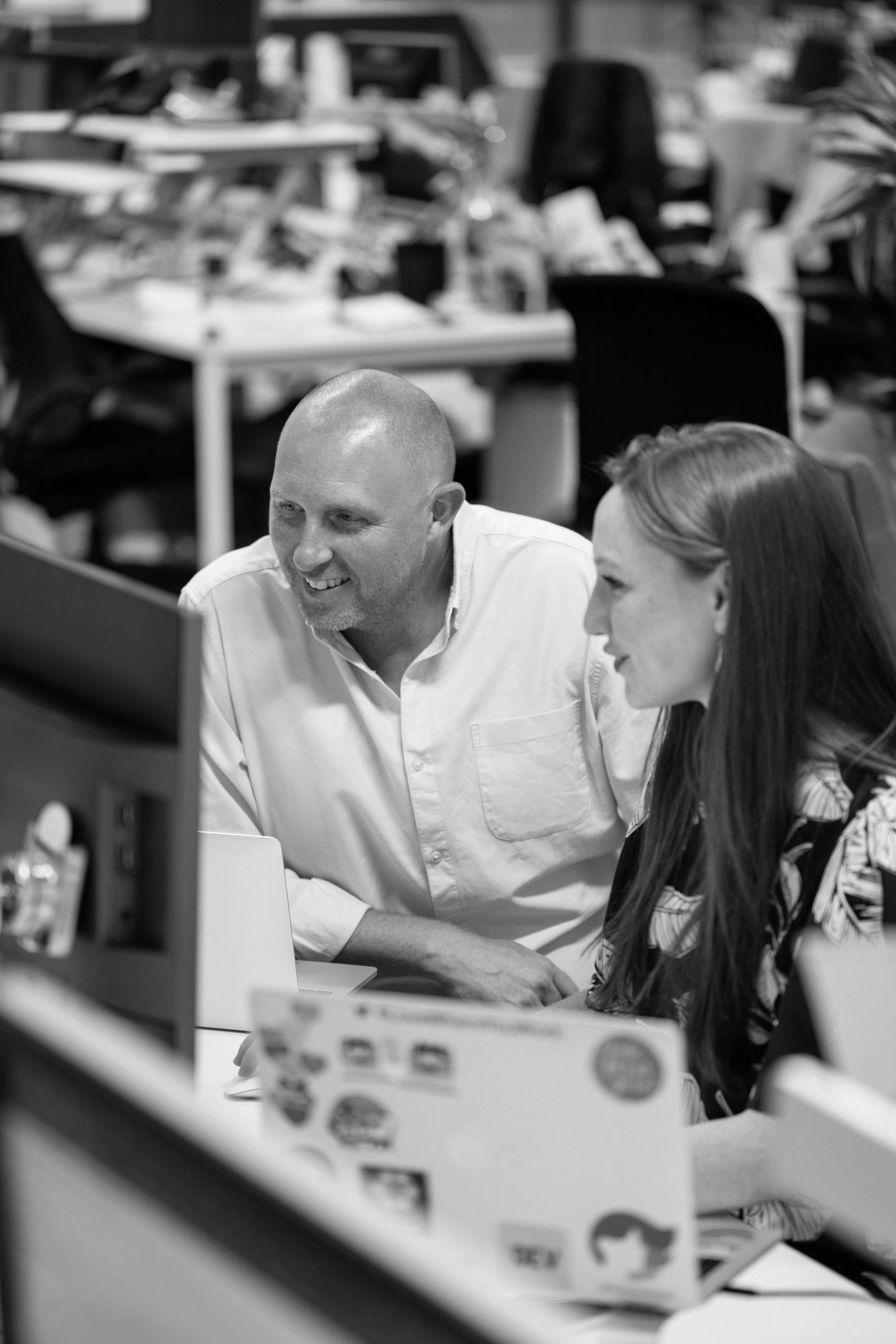 Man and woman looking at a computer screen in an office setting.