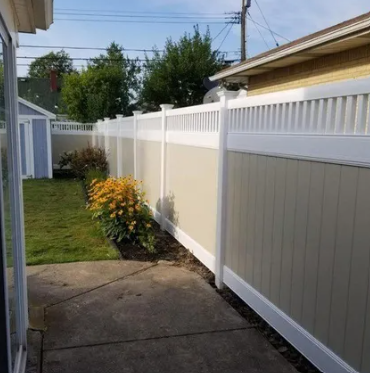 A modern white vinyl privacy fence installed by a residential fence contractor in a backyard.