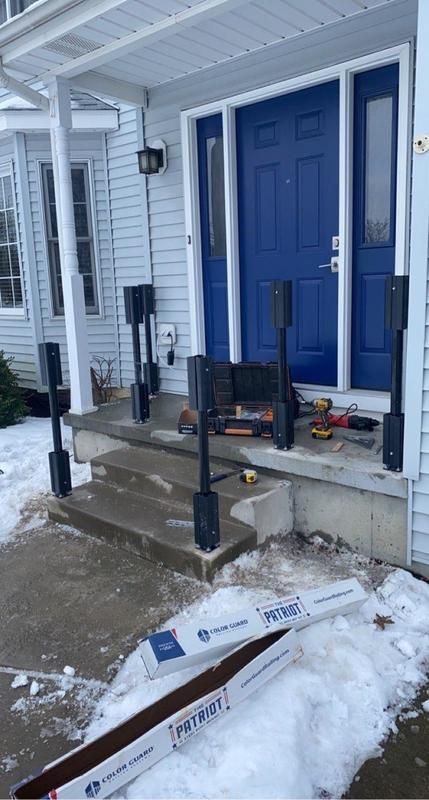 A blue door is being installed on the front of a house.