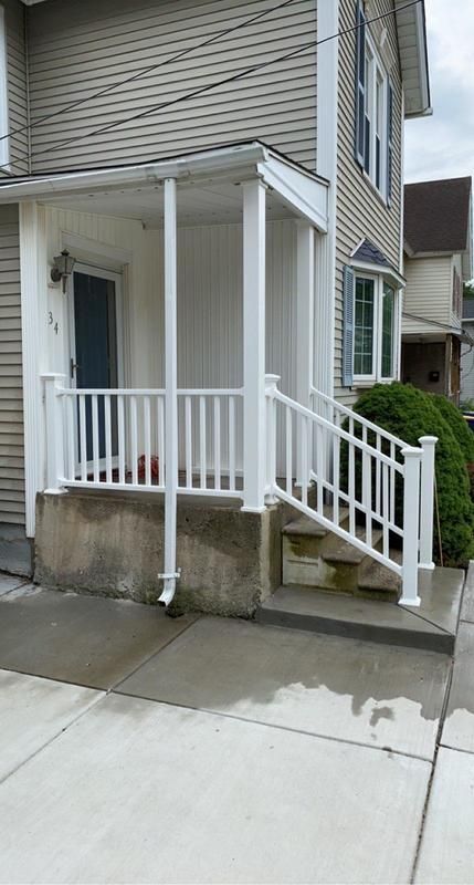 A house with a porch and stairs with a white railing.