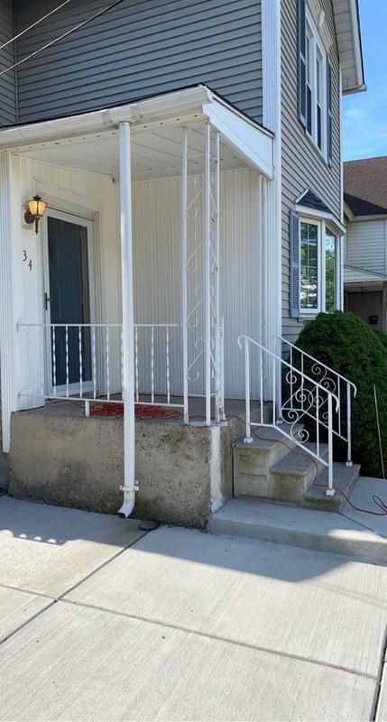 A white house with a porch and stairs