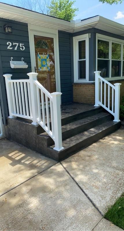 A blue house with white stairs and a white railing.