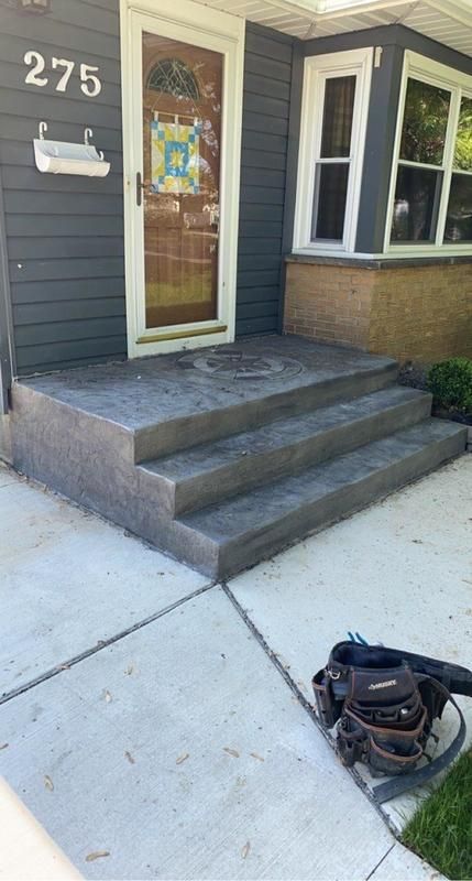 A bag is sitting on the sidewalk in front of a house.