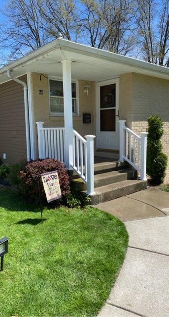 A house with a porch and stairs is for sale.