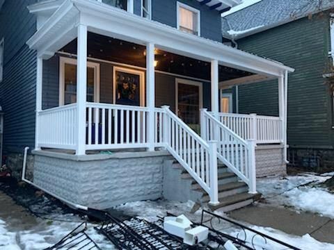 A blue house with a white porch and stairs.