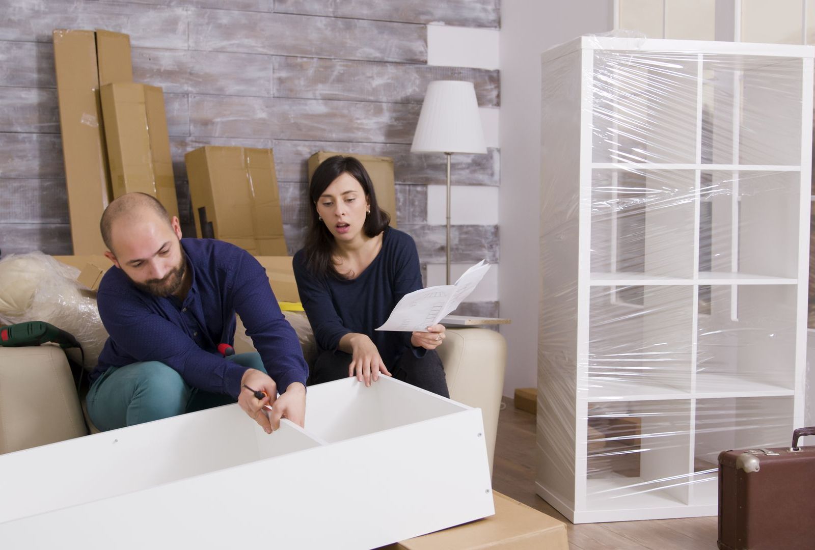 A man and a woman are sitting on a couch in a living room.