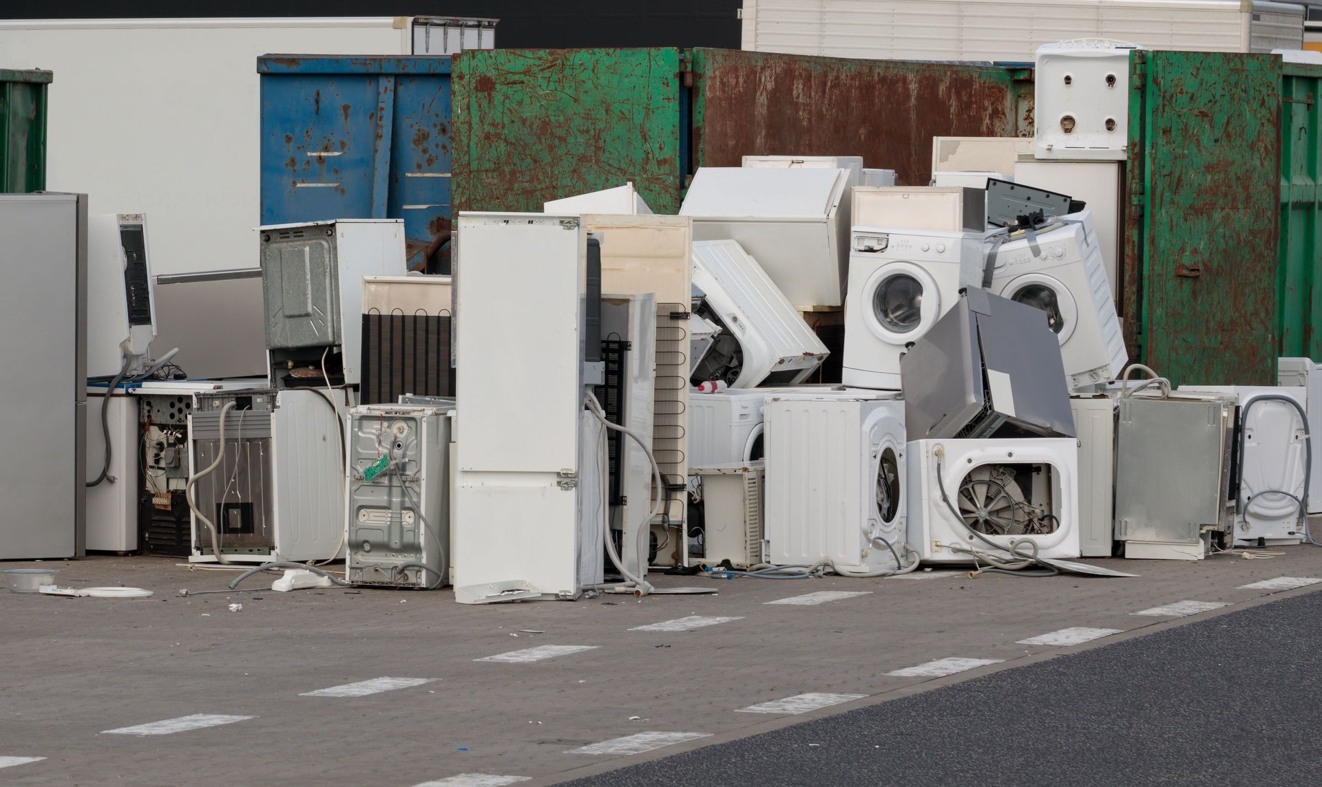 A pile of old appliances is sitting on the side of the road.