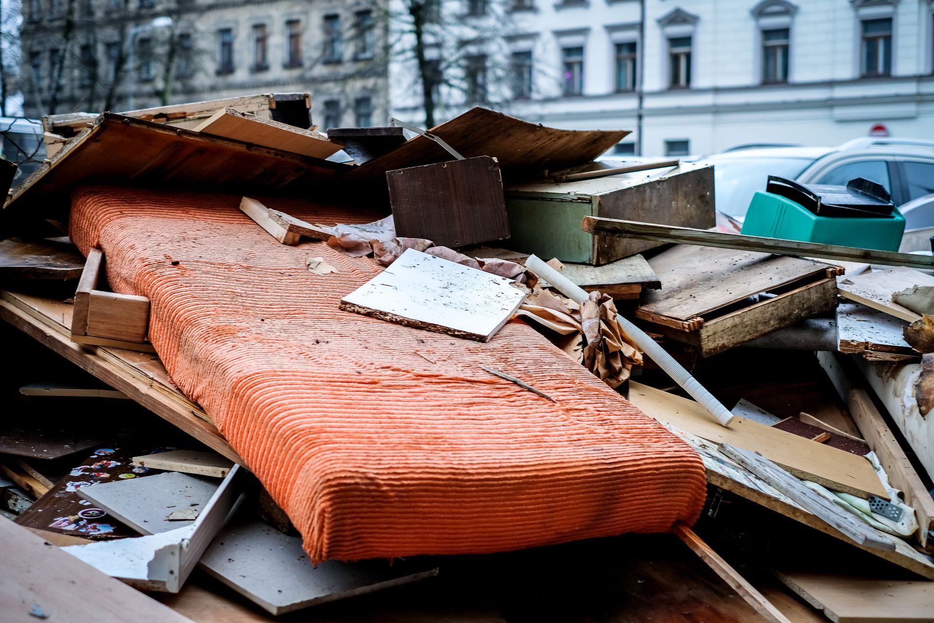 A pile of junk is sitting on the ground in front of a building.