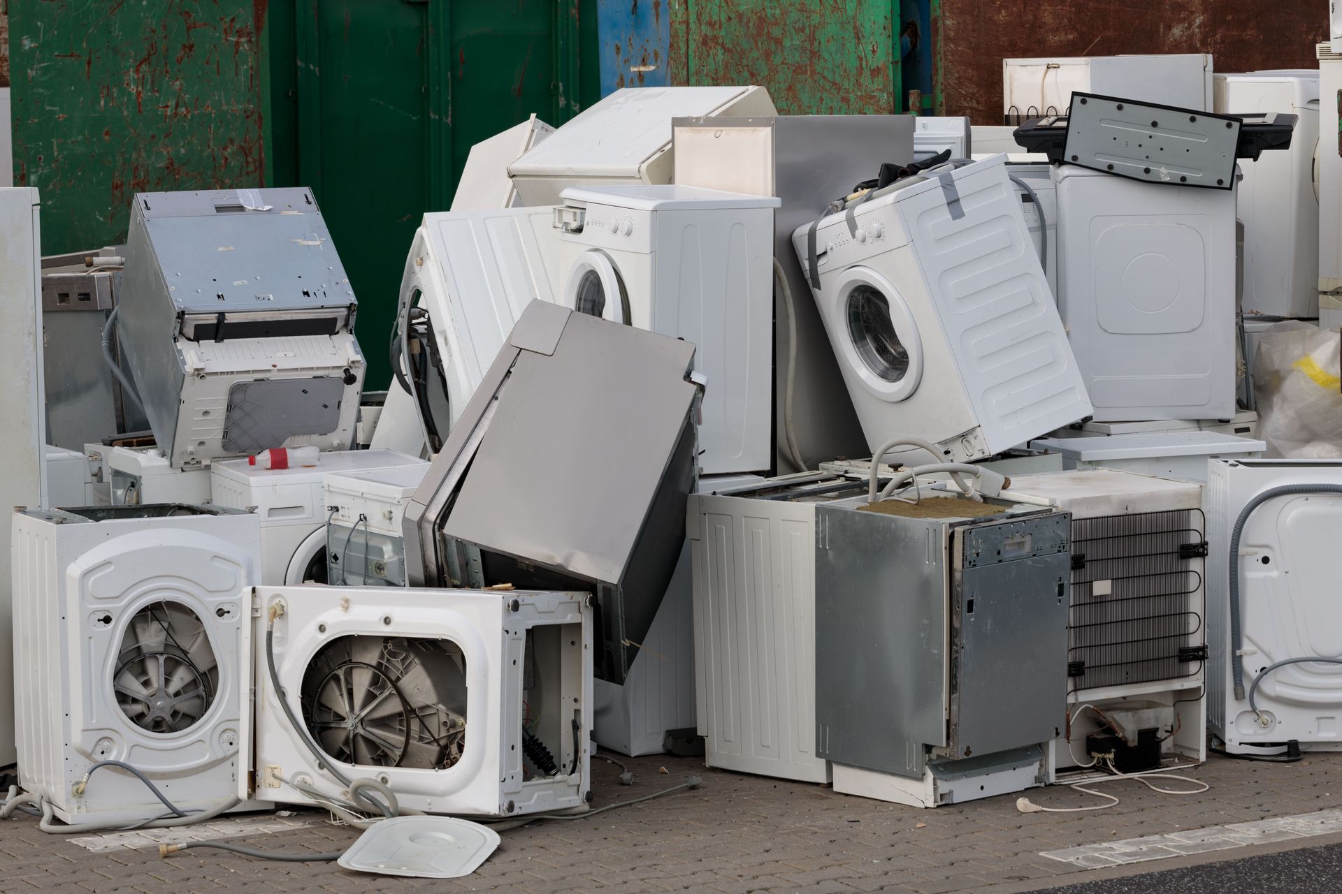 A pile of old appliances is sitting on the ground.