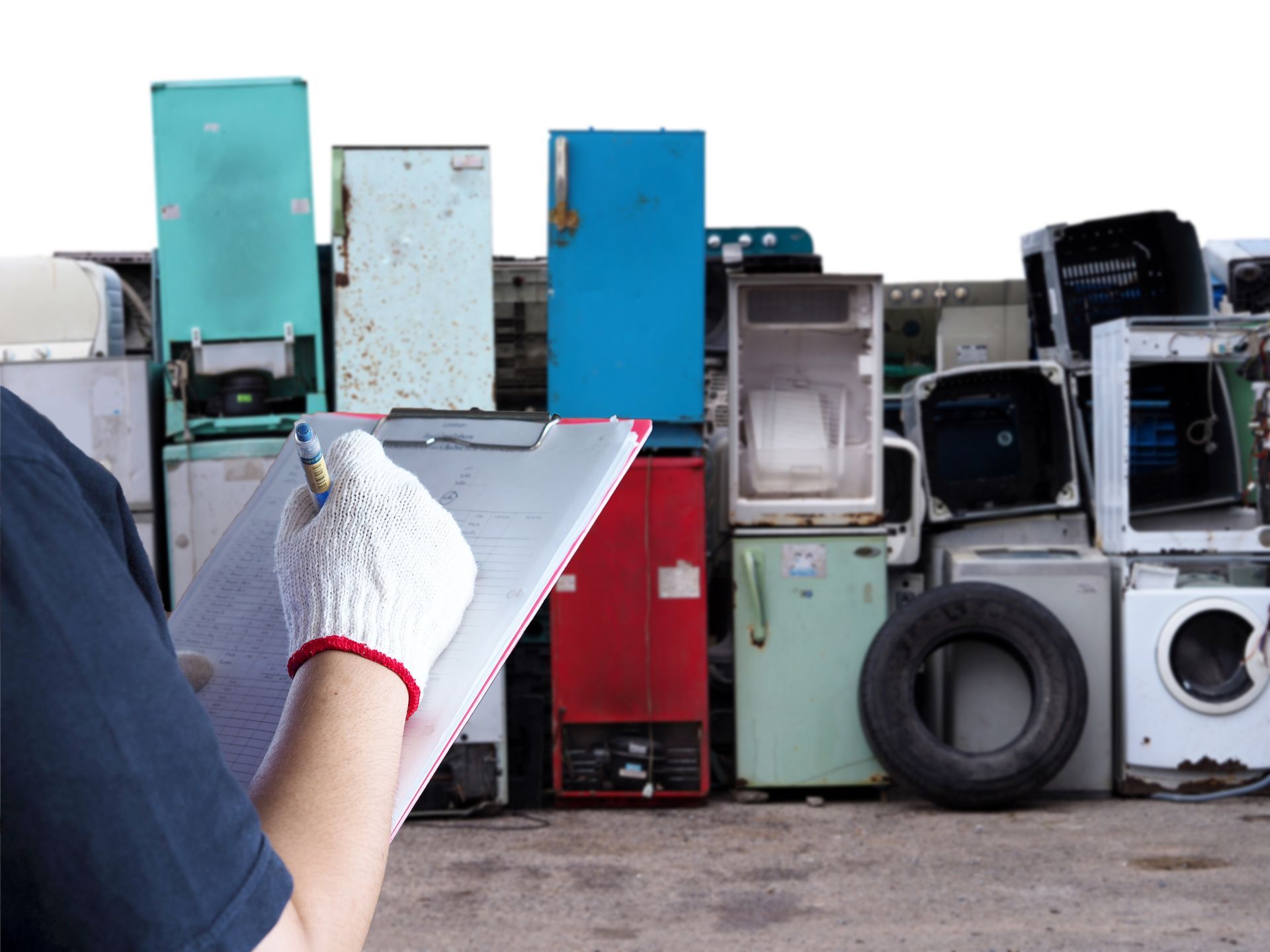 A person is holding a clipboard in front of a pile of appliances