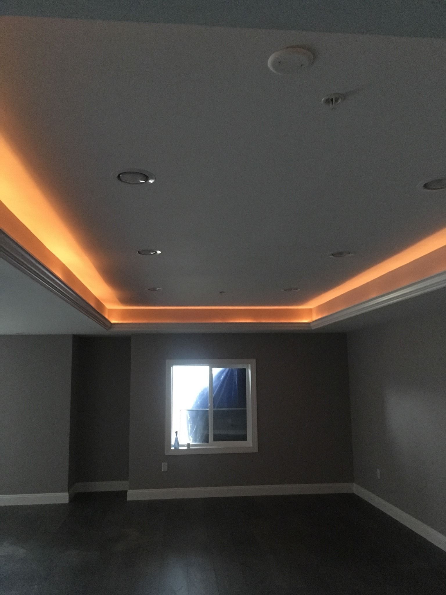 An empty room with a window and a light on the ceiling