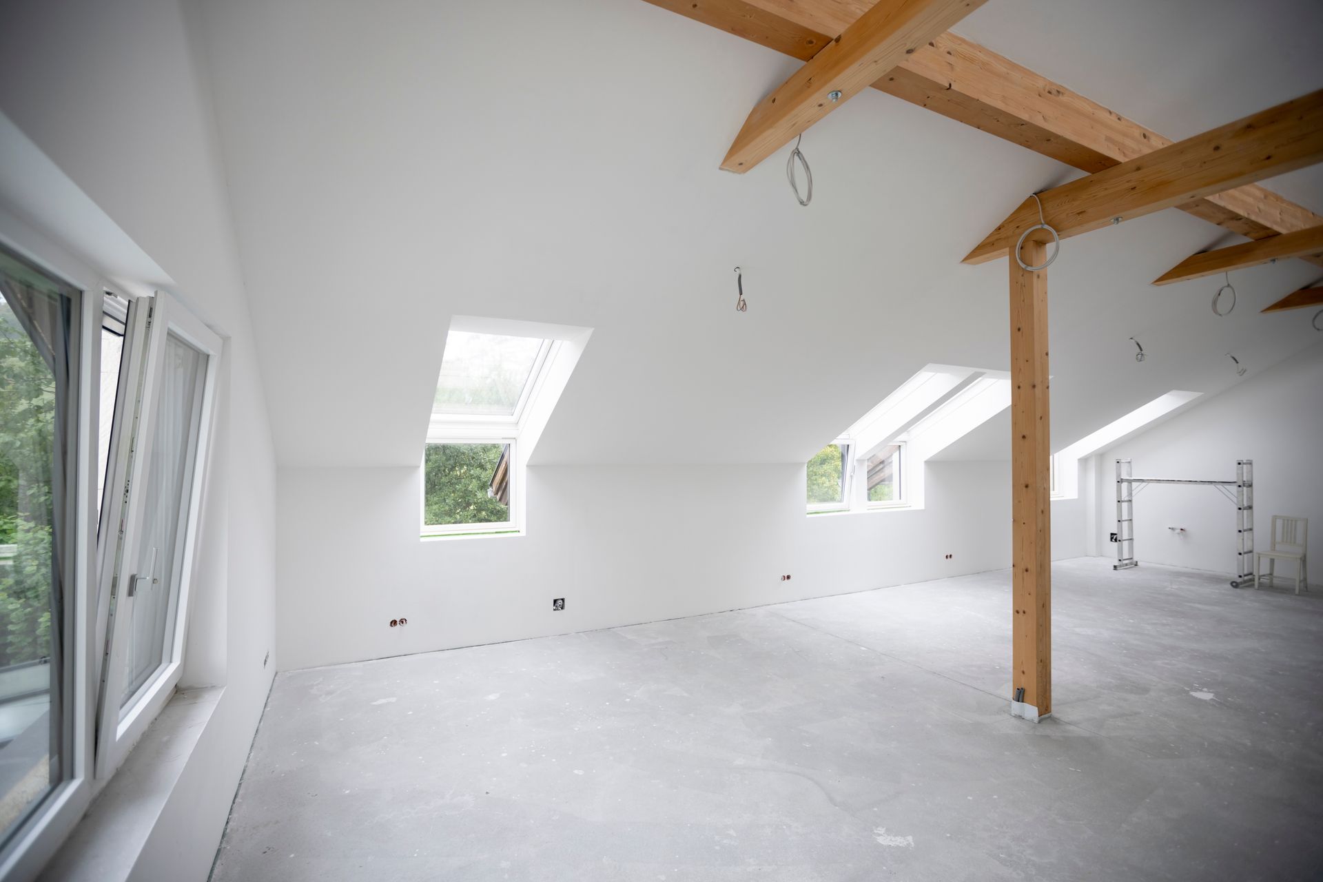 An empty room with white walls and wooden beams