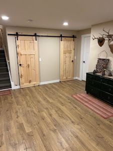 A living room with wooden floors and sliding barn doors.