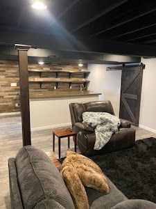 A living room with a couch , chair , table and sliding barn door.