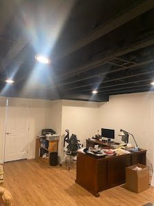 A room with a desk and a computer in it.