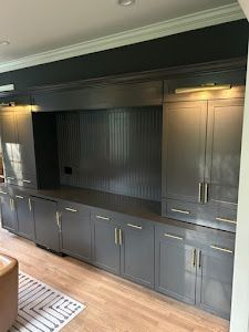 A living room with gray cabinets and a wooden floor.