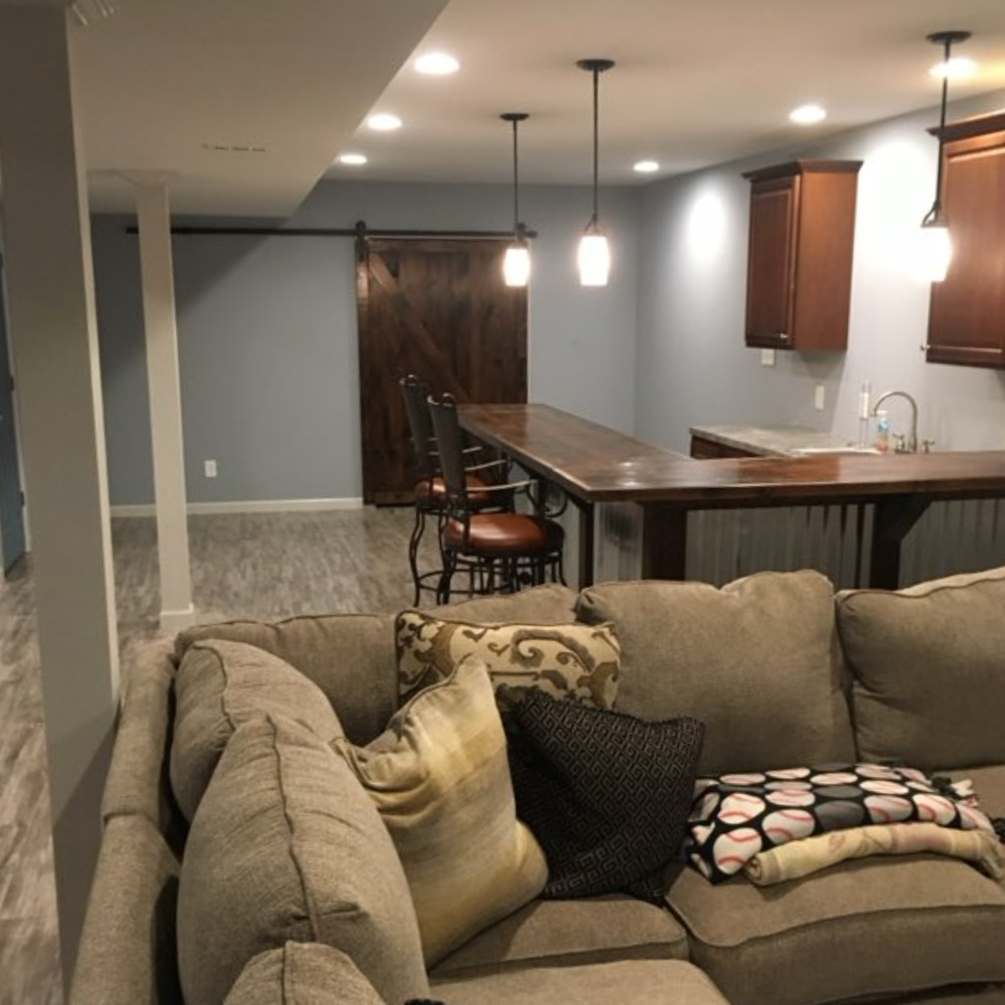 A kitchen with white cabinets , stainless steel appliances , and a large island.