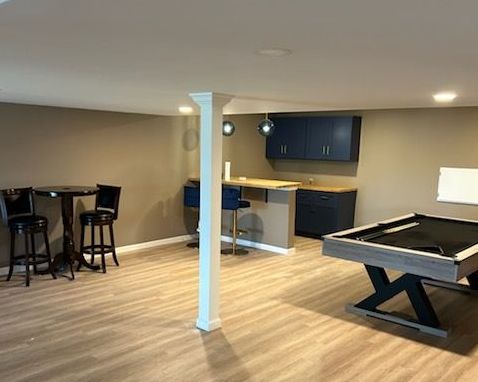 A drawing of a kitchen with white cabinets and a table and chairs.