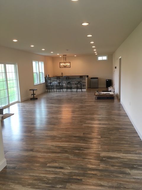 A large empty room with hardwood floors and a bar.
