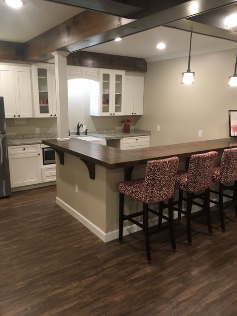A kitchen with a long counter and stools