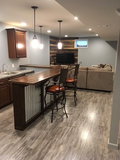 A kitchen with a bar and chairs in it
