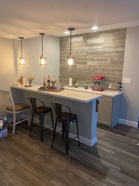 A kitchen with a bar , chairs and a popcorn machine.