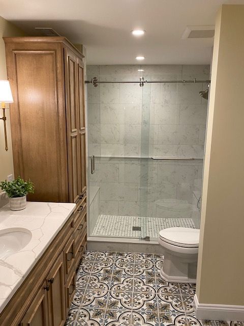 A bathroom with a toilet , sink , and walk in shower.