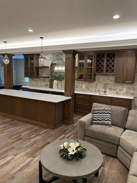 A living room with a couch , chair , table , and kitchen.