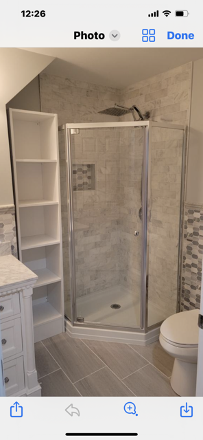 A bathroom with a walk in shower and a toilet