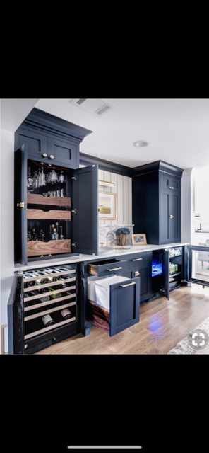 A kitchen with blue cabinets and a wine cooler.