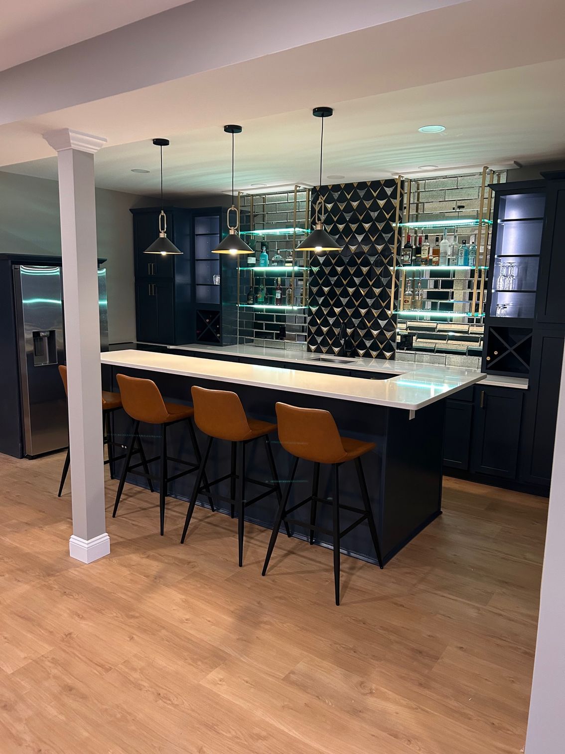 A kitchen with a bar and stools in it.