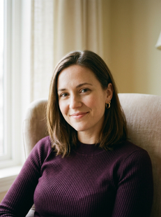 Woman sitting in armchair by window with warm smile, individual therapy Etobicoke