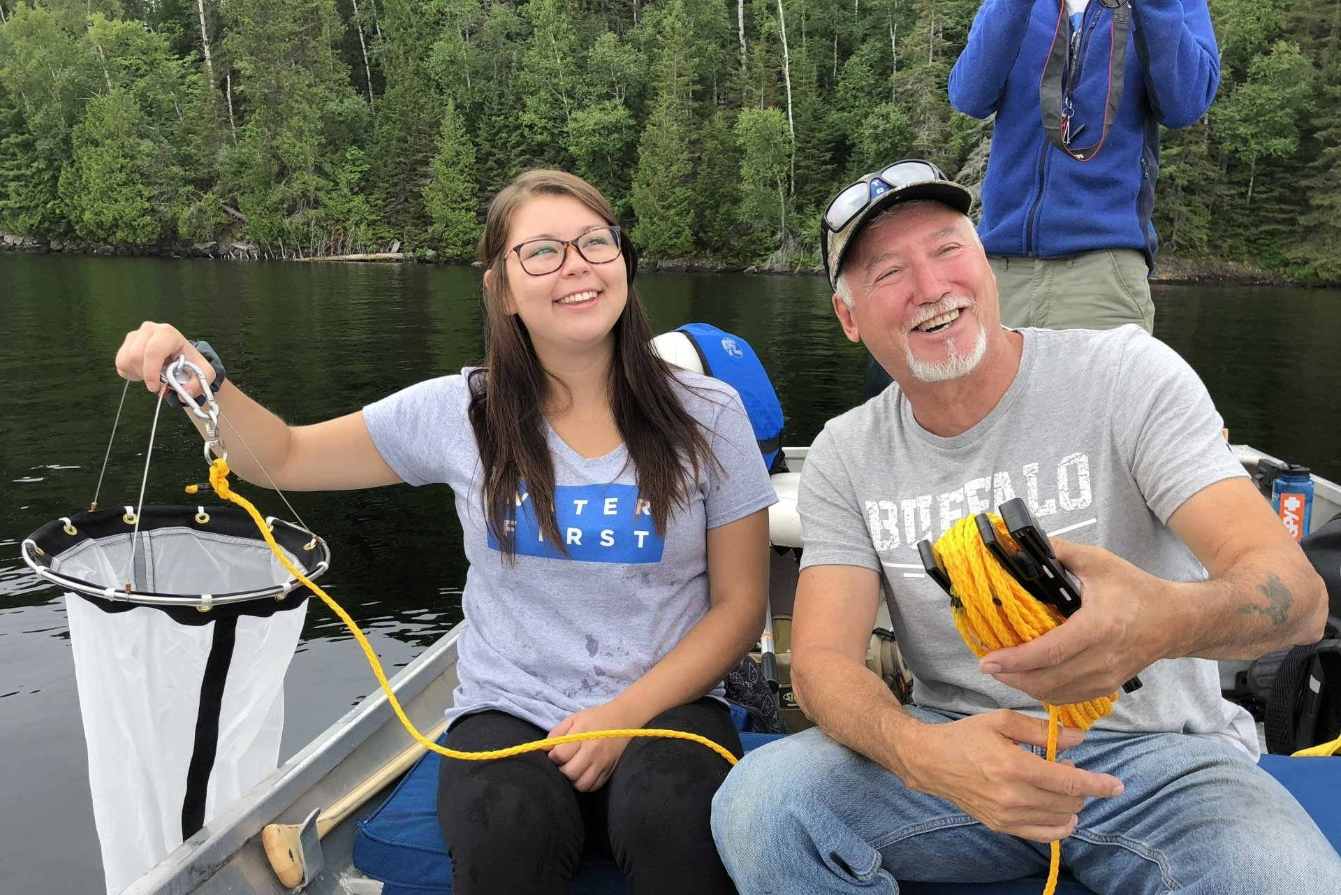 A man and a girl are sitting in a boat on a lake.