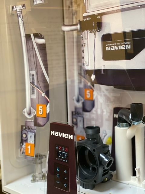 Cutaway diagram of Navien tankless water heater components, showing sections and labels. Includes the unit's controls and pump housing.