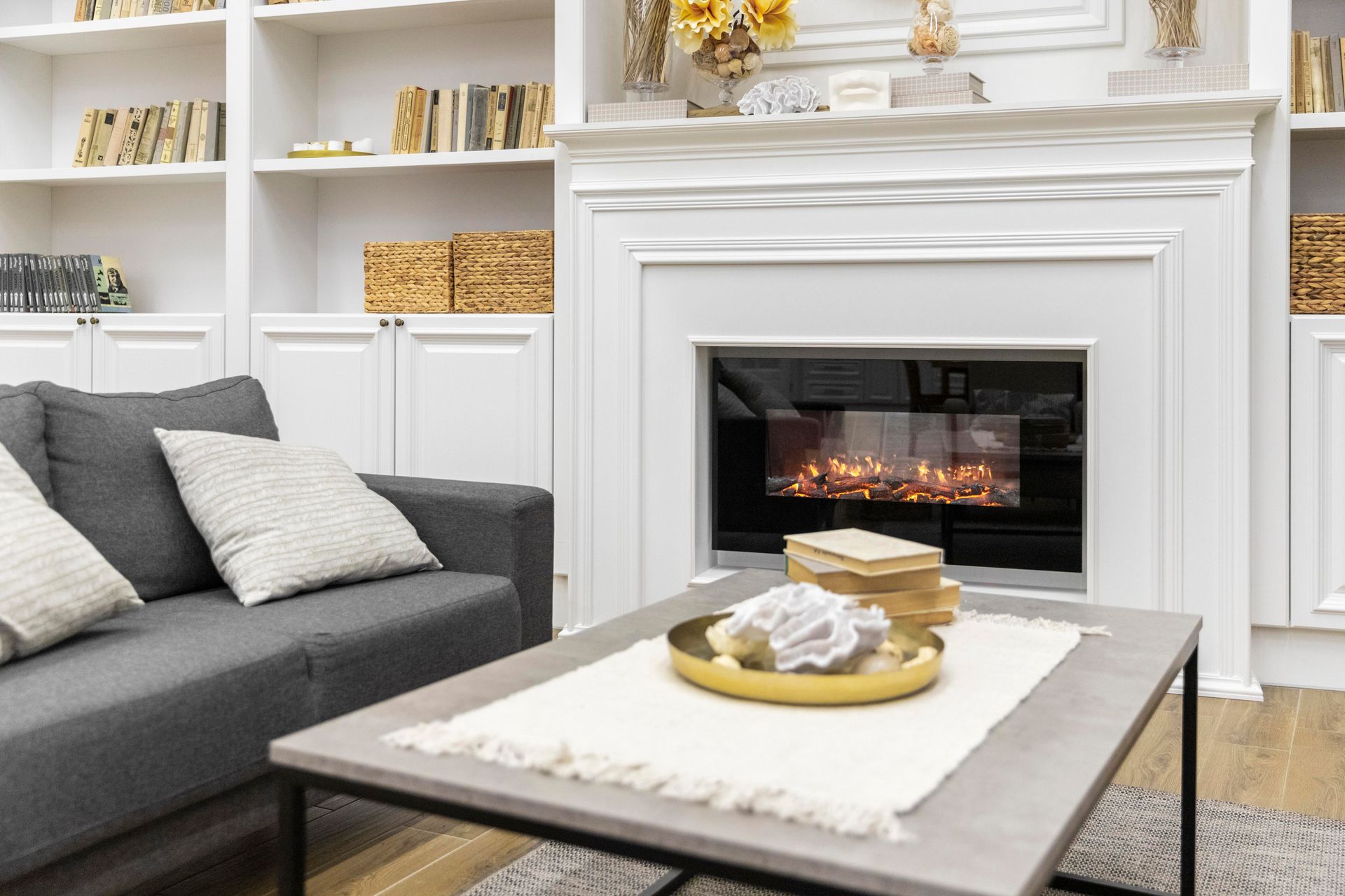 A living room with a fireplace , couch , coffee table and shelves.