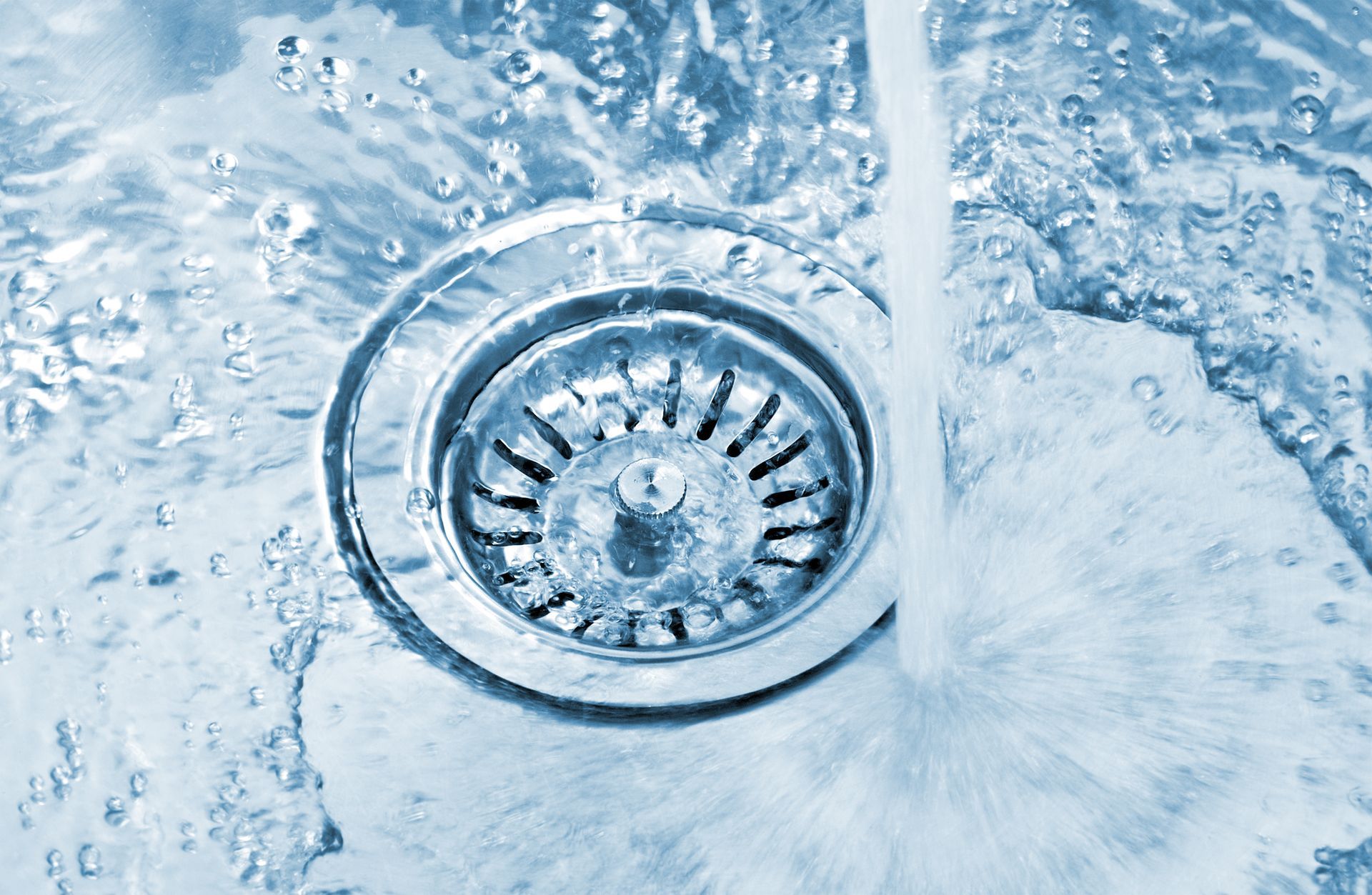 A close up of a sink with water running down the drain.