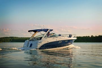 A white and blue boat is floating on top of a lake.