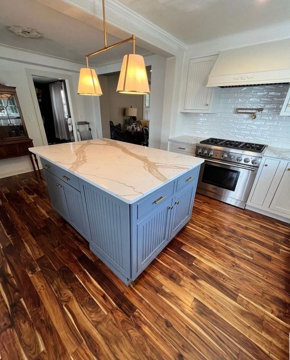Garage with brown brick exterior, tan garage doors, and a dark asphalt driveway.