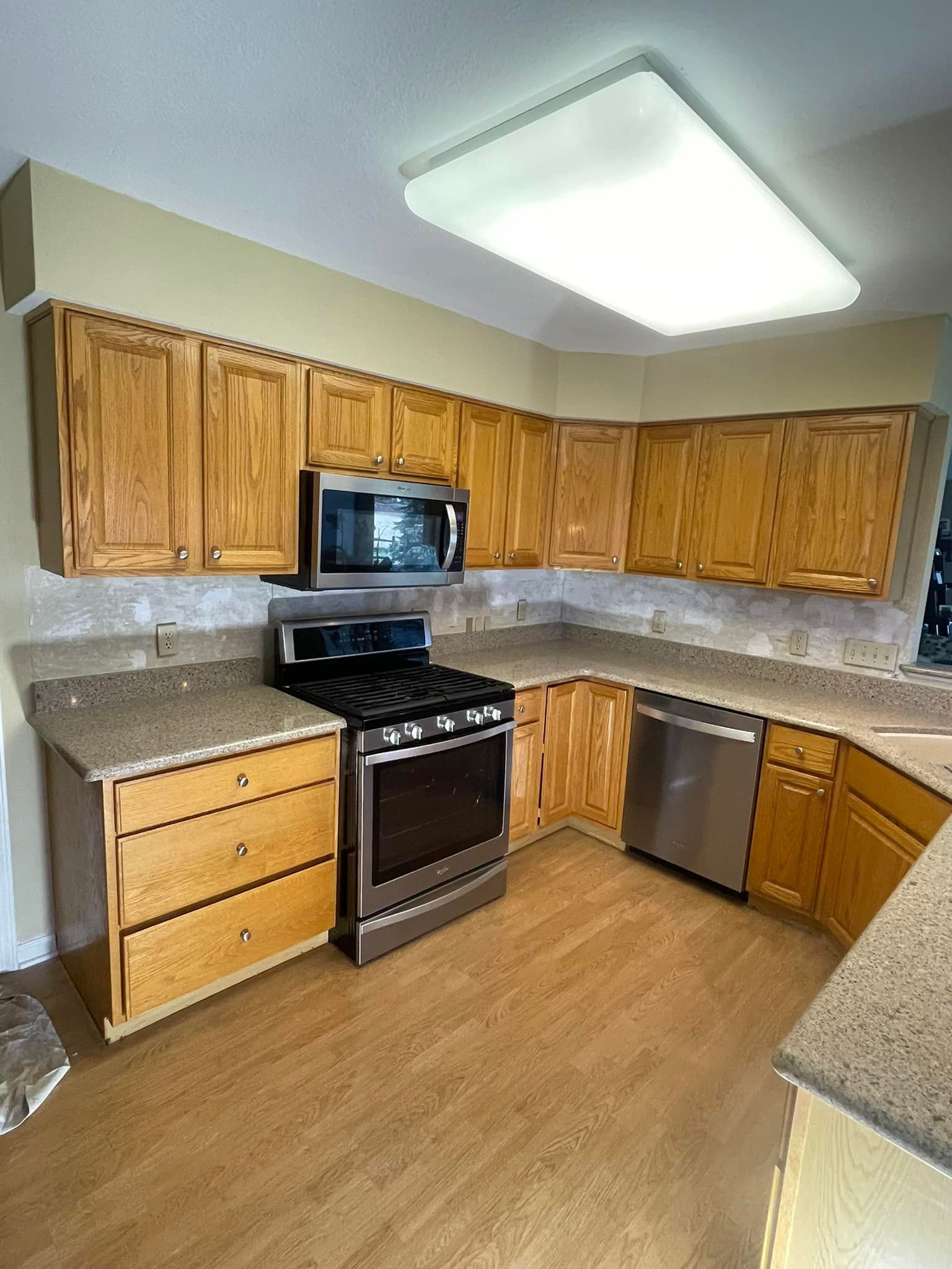 Kitchen with light-colored wood cabinets, stainless steel appliances, and beige 