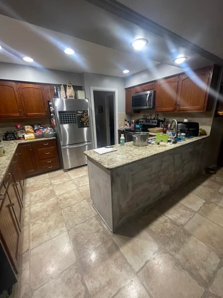 Kitchen with wood cabinets, stainless steel appliances, and island with countertop.