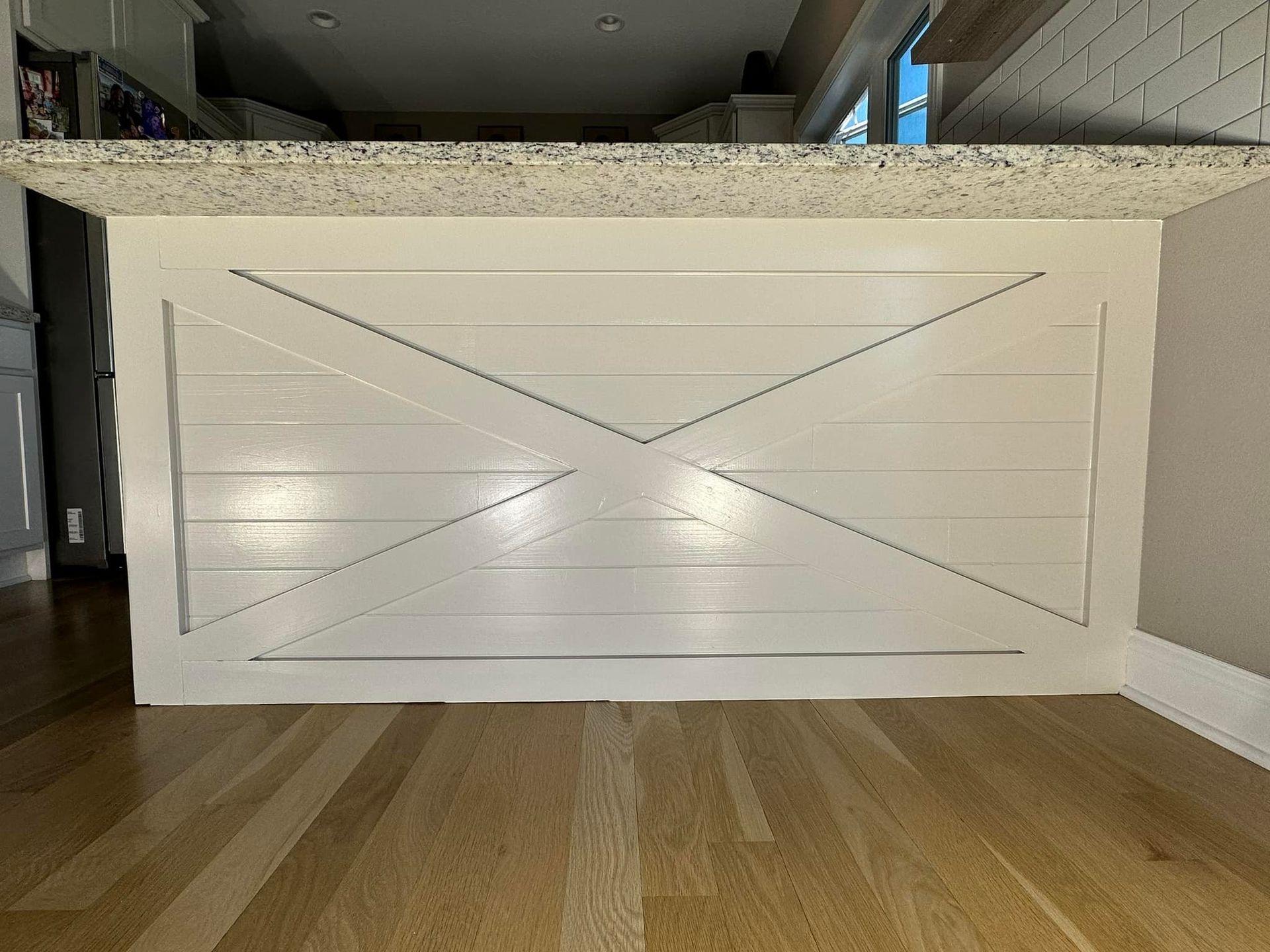 White kitchen island with horizontal planks and a decorative 
