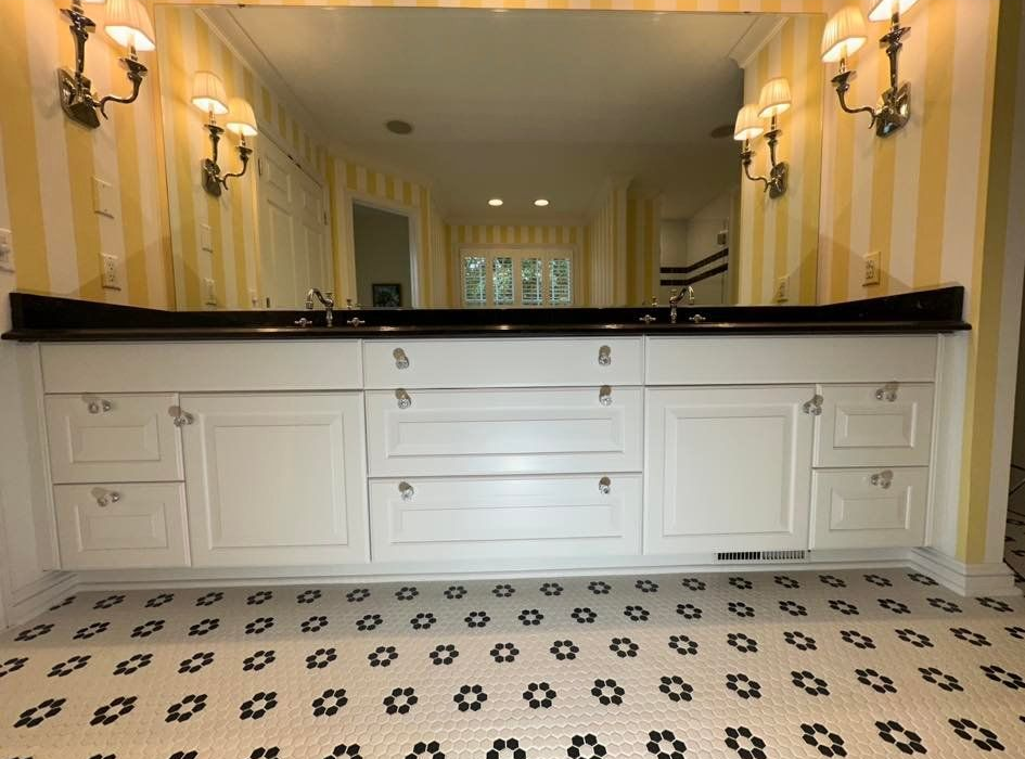 Bathroom with white cabinetry, black countertop, yellow and white striped 