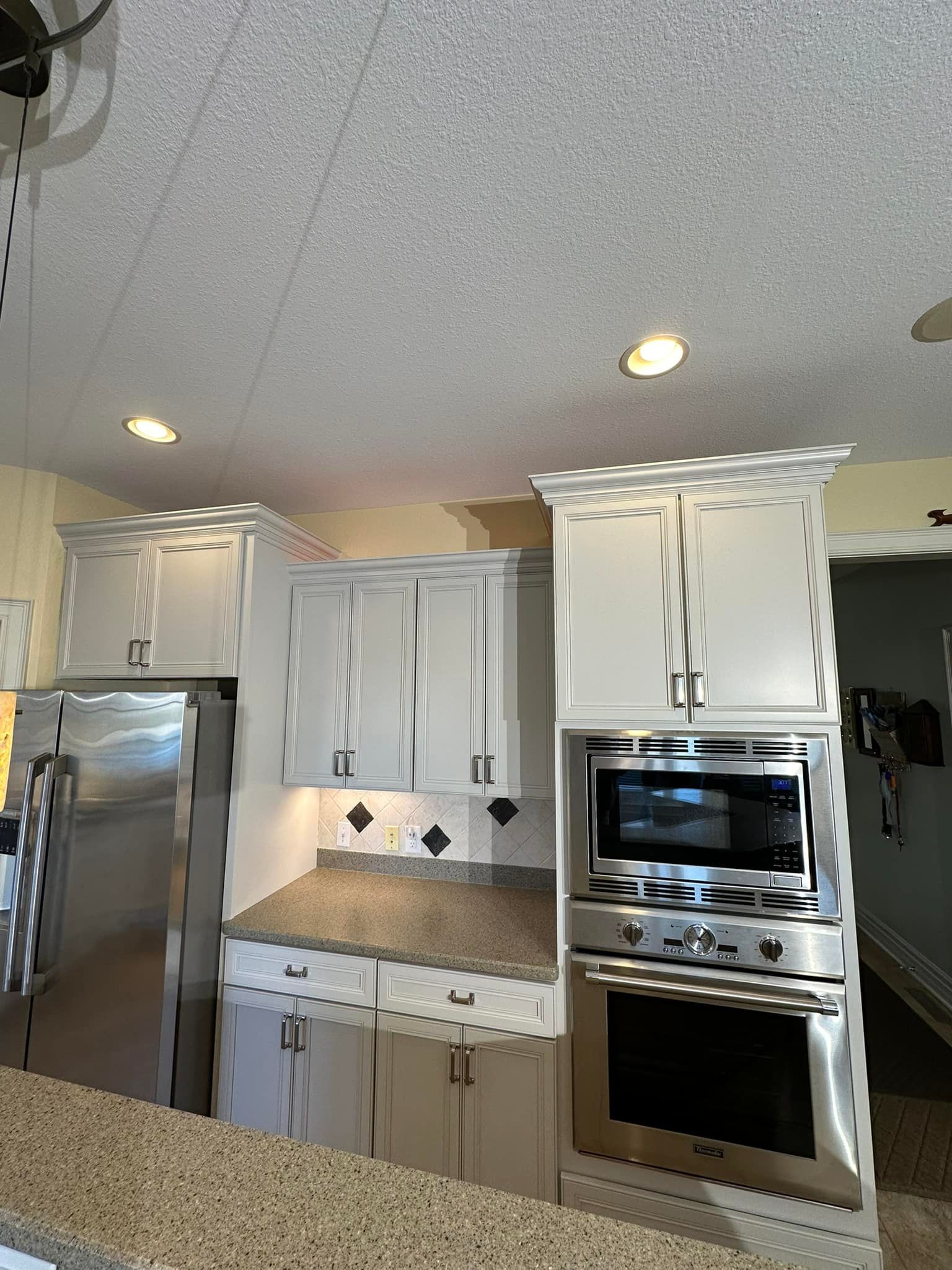White kitchen cabinets with appliances and granite countertop.