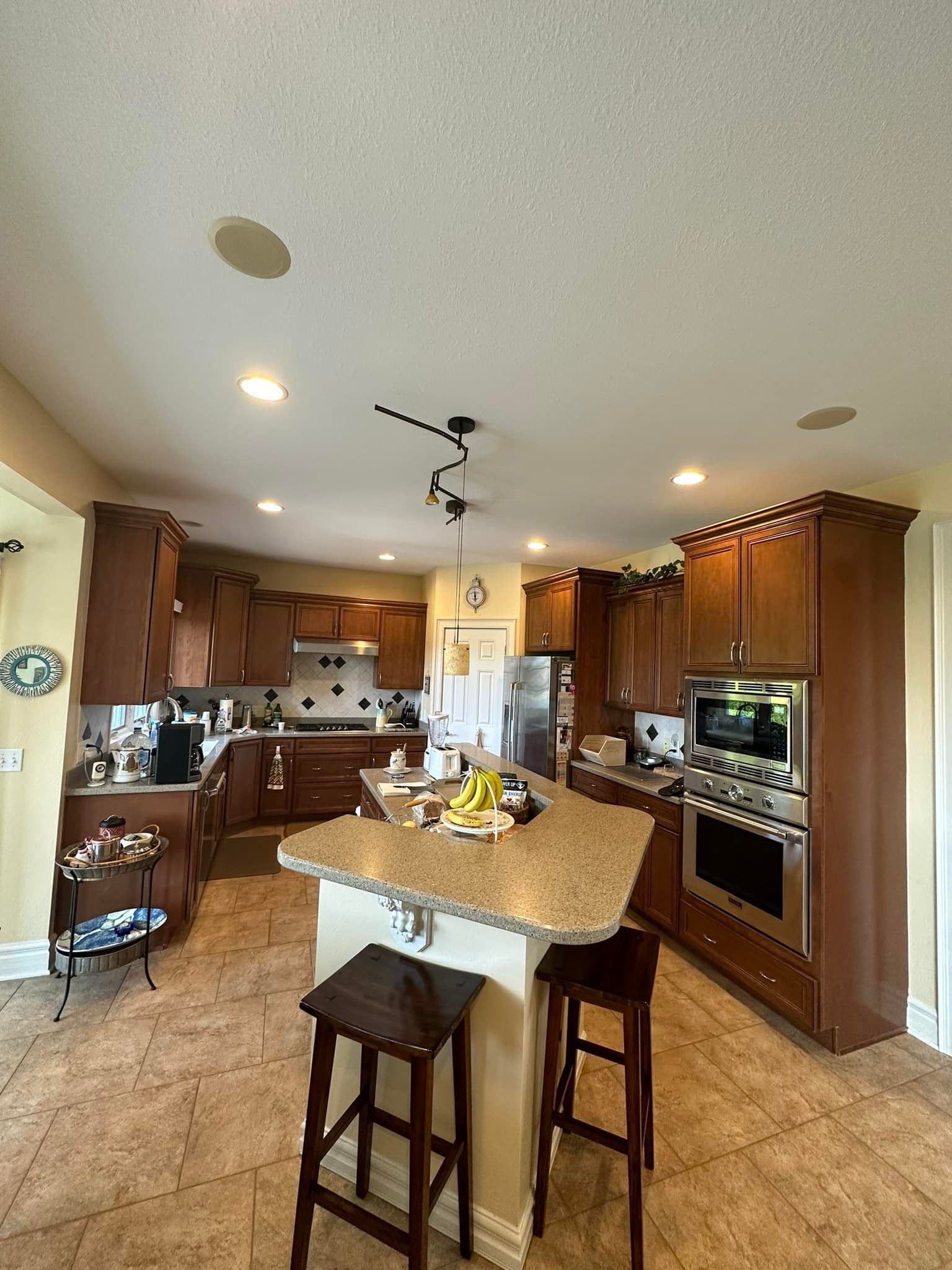 A kitchen with brown cabinets, a central island, and stainless steel appliances.
