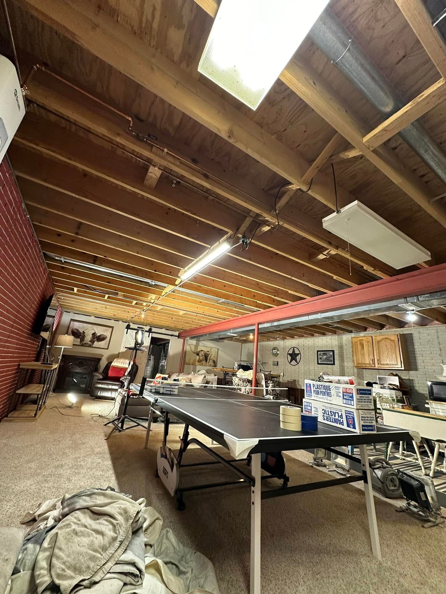 Workshop interior with high angled wood ceiling, work tables, and various equipment.