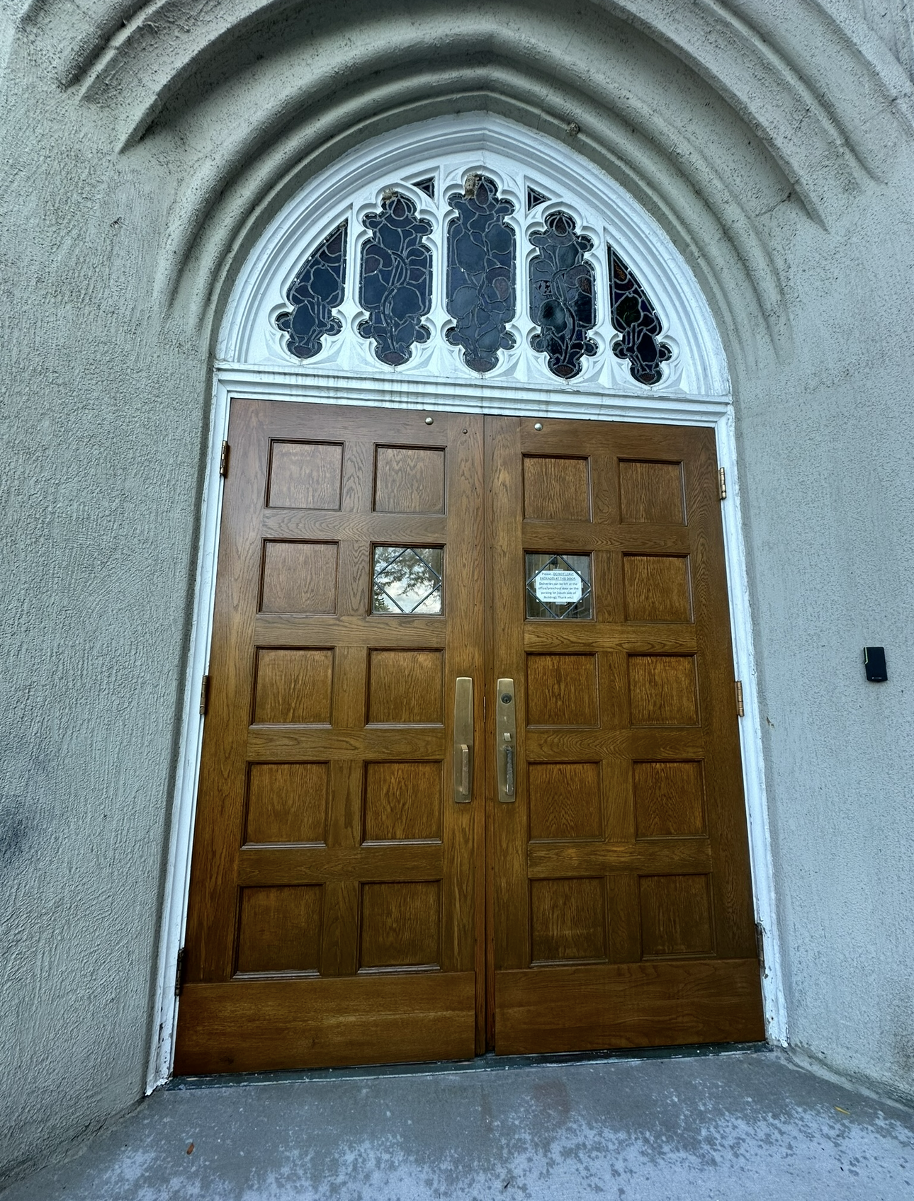 Kitchen with a gray island, wooden floor, and a breakfast bar with two stools.