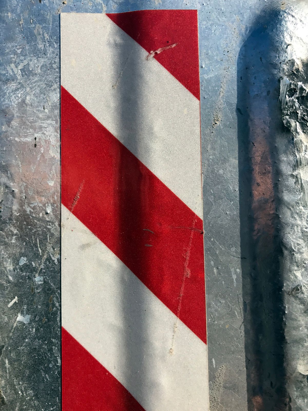 A weathered blue and white porch with a railing and steps, under a light blue roof.